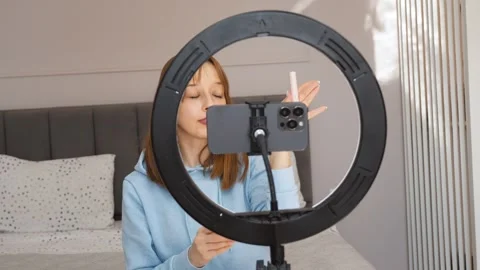 Beauty influencer applying lipstick while recording makeup tutorial Stock Footage 314525662