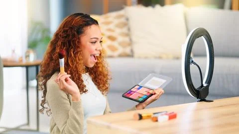Beauty influencer filming a makeup tutorial at home. Young female blogger live Stock Photos