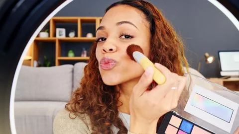 Beauty influencer filming a makeup tutorial at home. Young female blogger live Stock Photos