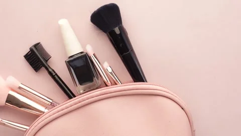 Beauty makeup accessories falling into pink cosmetic bag on pastel backgrou.. Stock Footage 332623662