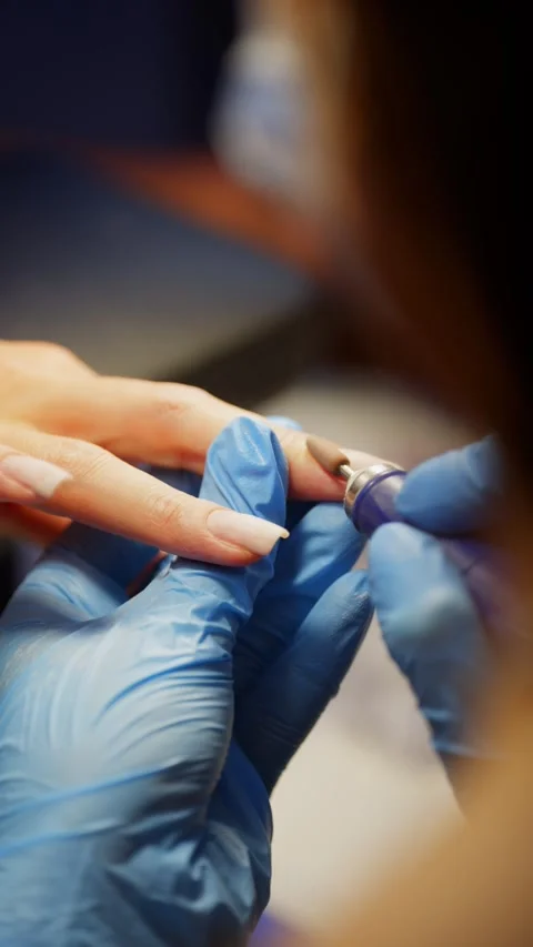 Beauty master performing delicate nail shaping manicure with precision and focus Stock Footage 319879659