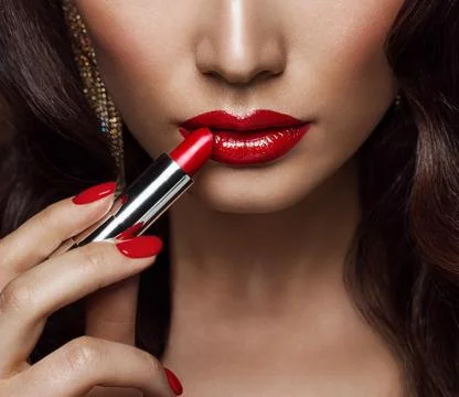 Beauty Model applying Red Lipstick. Perfect Lips Make up and Nail Polish Closeup Stock Photos