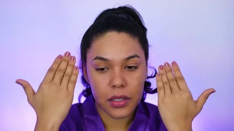 Beauty model applying serum on her face for a perfect pre-makeup routine Stock Footage