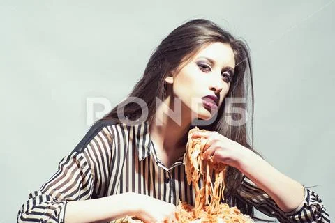 Beauty model with makeup and long brunette hair have dinner. Sexy woman eat Stock Photos