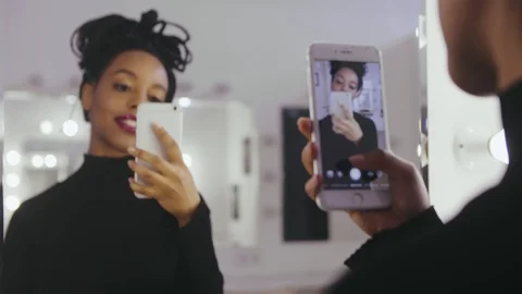 Beauty model photographing its reflection in makeup mirror on mobile phone Stock Footage 86466183