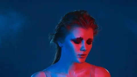 Beauty model posing in bright neon lighting, expressively looking in camera. Stock Footage 125322689