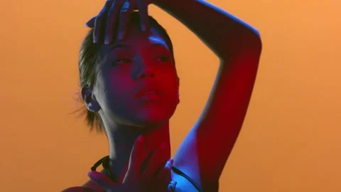 Beauty model in red blue light turns head hand on hair Stock-Footage 337132890