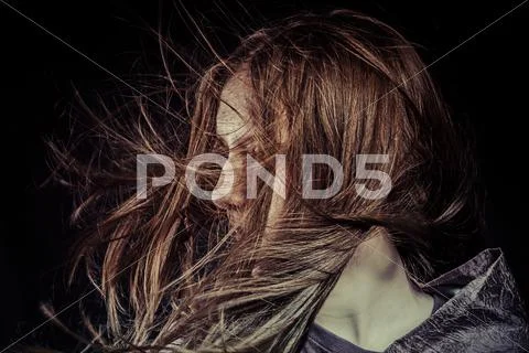 Beauty model in studio with hair blown by wind Stock Photos