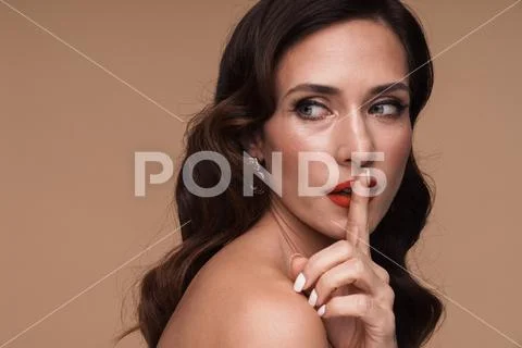 Beauty portrait of brunette adult half-naked woman going shh gesture