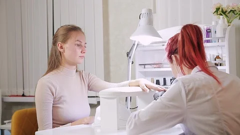 In the beauty salon, the master makes the client cover the client's nails with a Stock Footage 118274195