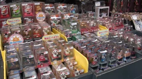 Beckoning cats and other dolls for sale at a tourist market in Tokyo, Japan Stock Footage