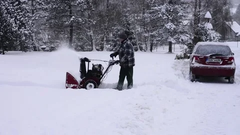 Becva, Czech Rep Jan 22nd 2022. Man clearing the snow off the driveway with a Stock Footage 169301583
