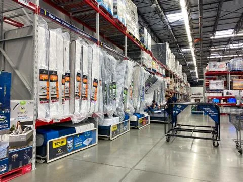 The bed aisle of a Sams Club with variety of mattresses ready to be tried out Stock Photos