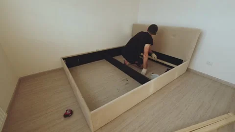 The bed assembly process, the master assembles the bed Stock Footage 282477760