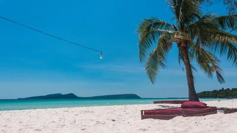 A bed at the beach under a plam tree Stock Photos