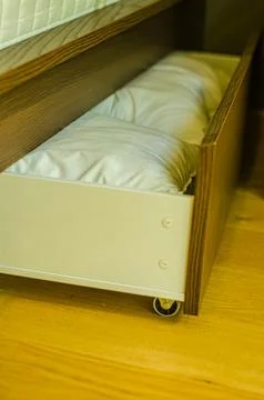 Bed box, home storage, under-bed drawer, household organization solution Stock Photos