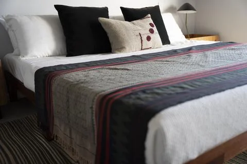 Bed with decorative covers and pillows Stock Photos