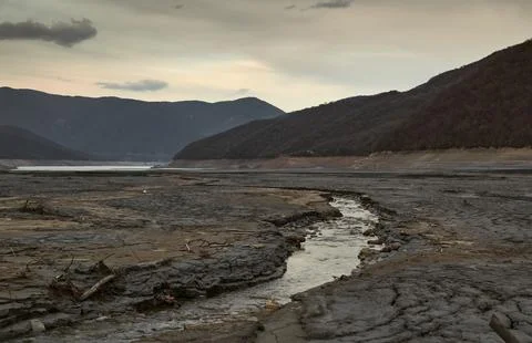 The bed of the drying up river goes far into the still full-flowing area, around Stock Photos