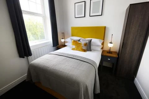 Bed, empty room and hotel interior design or home decor accommodation or weekend Stock Photos