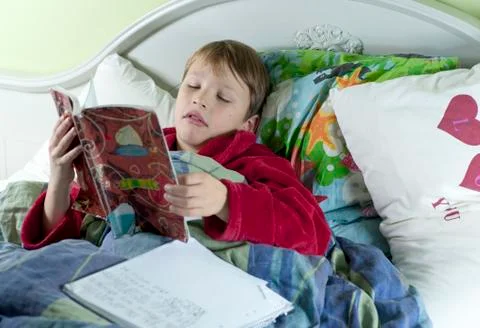 In bed with the flu doing schoolwork Stock Photos