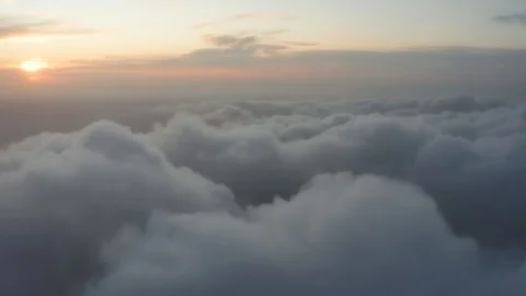 Bed of fluffy clouds with an orange sunset backdrop Stock Footage 120699642