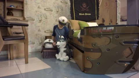 Bed in the form of a pirate ship. The boy wears a captain's cap Video stock 80016413