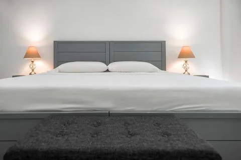 Bed with gray details and two warm lamps white background 스톡 일러스트
