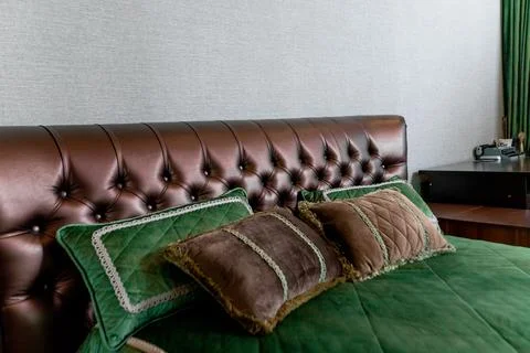 A bed with a green comforter and pillows Foto stock