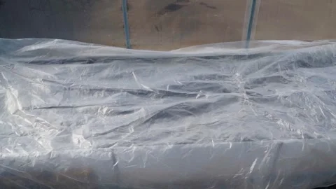 A bed in a greenhouse is covered with plastic wrap. Protection against cold Stock Footage 312195485