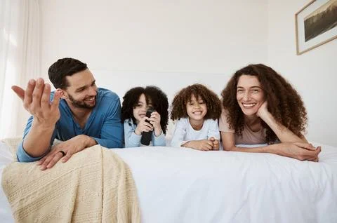 Bed, happy family children and parents watching tv series, movies or online Stock Photos