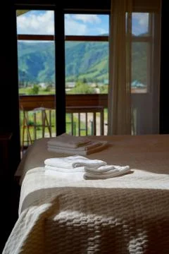 A bed in hotel suit with window in background with beautiful mountains view Stock Photos