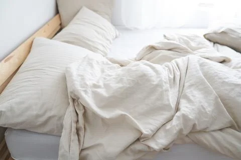 A bed in the interior of the room. The bed is not made. Beige color Stock Photos