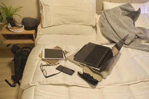 Bed with laptop tablet and study materials Фото