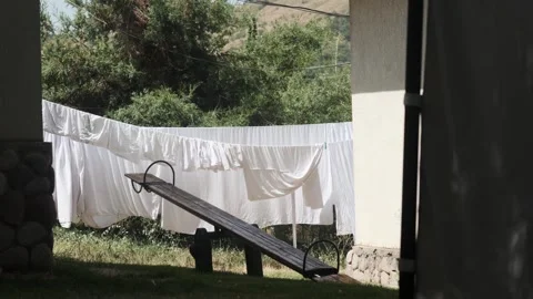 Bed linen is dried on ropes in the wind in the courtyard of the house. There is Stock Footage 248419572