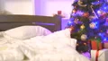 The bed near the christmas tree with a garland 4k or 4k+ Resolution