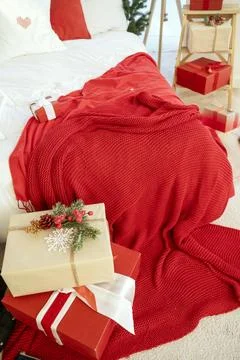 Bed with New Year's decor. There is a red bedspread on the bed. Stock Photos