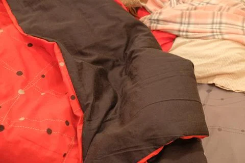 Bed not made red blanket on the product after sleeping a person in an apartment Stock Photos