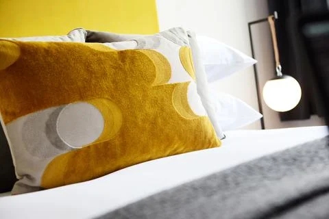 Bed, pillow and interior of hotel room with hospitality, accommodation and Stock Photos