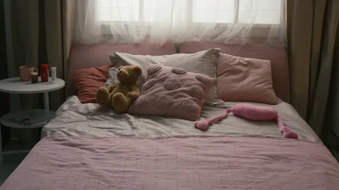 Bed with Pillows and Plush Bear near White Side Table Showing Pill Bottles Stock Footage 335468610