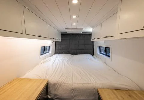 Bed room area of a converted sprinter van camper Stock Photos