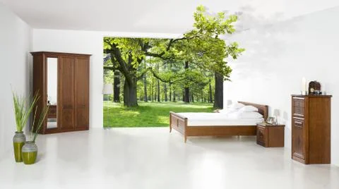 Bed in the room opened on the forest - concept of good sleep Stock Photos