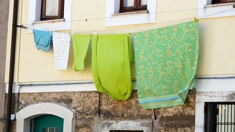 Bed sheet hanging on a clothes line in the city Stock Footage 79546679