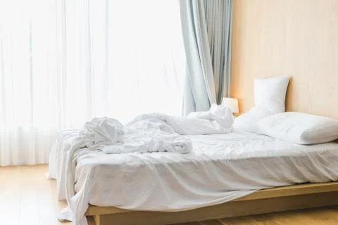 Bed sheets and pillows messed up after nights sleep ,comfort and bedding in a Stock Photos