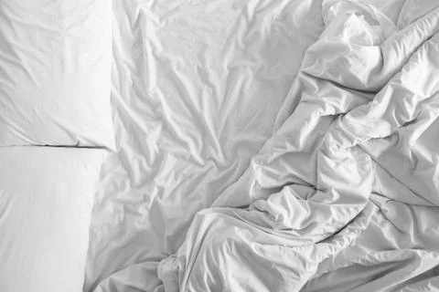Bed sheets and pillows messed up after nights sleep ,comfort and bedding in a Stock Photos