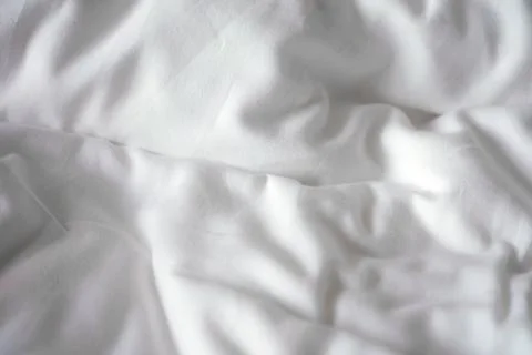 Bed sheets soft white wrinkly texture background. Photos
