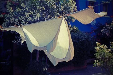 Bed sheets spread to dry in the sun in a small village in the mediterranean a Stock Photos