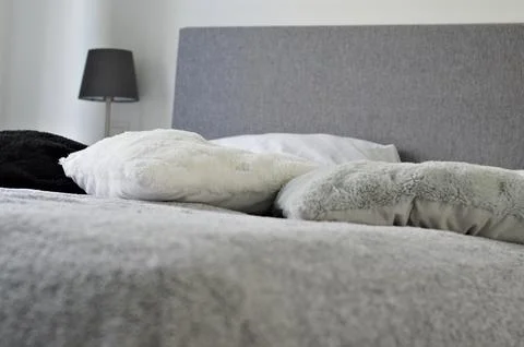 Bed with soft pillows. Interior stylish room with big bed Stock Photos