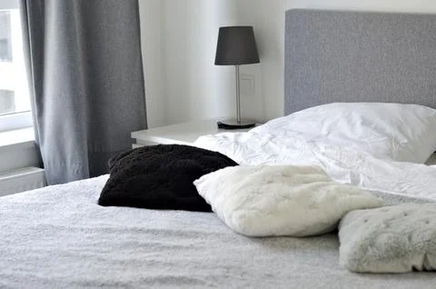 Bed with soft pillows. Interior stylish room with big bed Stock Photos