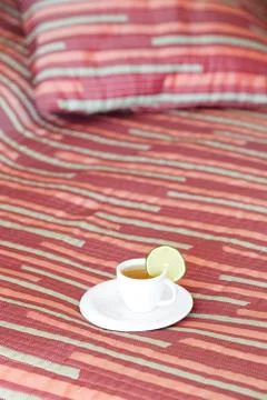 Bed with two pillows, a cup of tea on the blanket Stock Photos