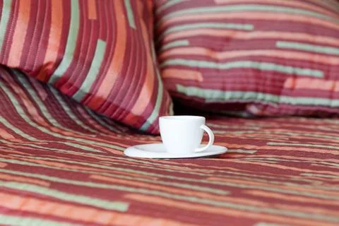 Bed with two pillows, a cup of tea on the blanket Stock Photos